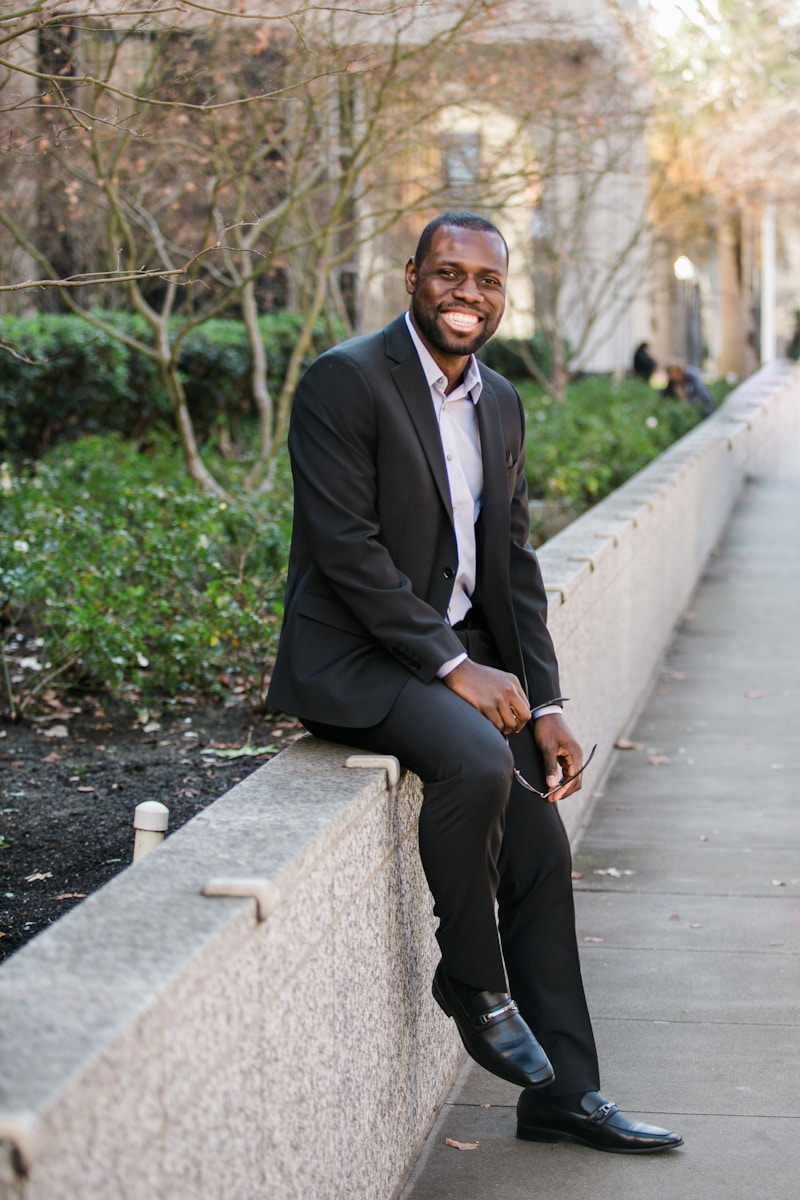 man in black suit jacket and black pants with bop standing on pathway